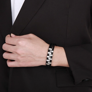 Detail of multi-layer black braided leather bracelet with silver geometric metal accents