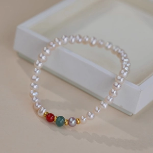 Elegant freshwater pearl bracelet with colorful natural stones and gold accents on a white box