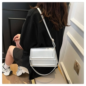 Detailed view of silver crossbody bag with flap and adjustable slim shoulder strap