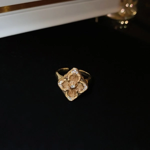 Macro shot of gold-plated vintage clover ring featuring sparkling diamond accents on black back