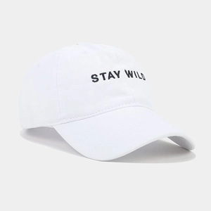 Detail of white cotton baseball cap with black STAY WILD embroidery at 45-degree angle