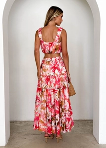 Vue arrière d'un ensemble crop top fleuri et jupe longue dans un décor blanc épuré