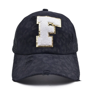 Close-up of distressed baseball cap with white towel embroidered letter F and sequins