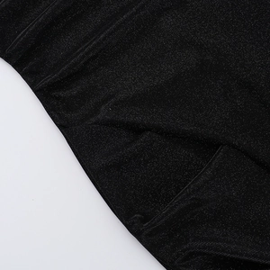 Detail of elegant black shimmering fabric with fine glitter particles and pleated texture