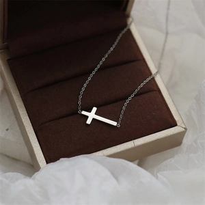 Close-up of horizontal cross necklace in a champagne gift box with velvet lining