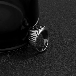 Detail of silver dollar sign ring with side textured bands on dark grainy background