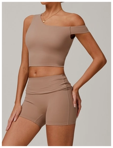 Détail d'un ensemble de yoga rose moka avec haut asymétrique et short de sport taille haute