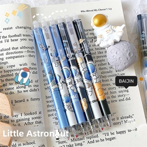 Detail of six erasable gel pens with astronaut themes on an open book background