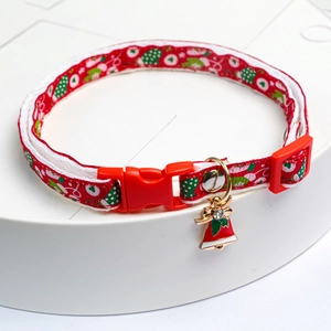 Macro detail of Christmas pet collar featuring festive patterns and rhinestone charm
