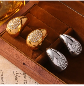 Détail de boucles d'oreilles en forme de goutte avec zircon en or et argent poli