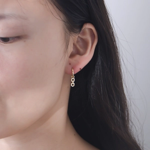 Close-up of gold 925 sterling silver earrings with interlocking rings on a model