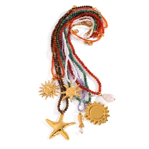 Detail of colorful beaded necklaces with gold sun and starfish pendants on white background