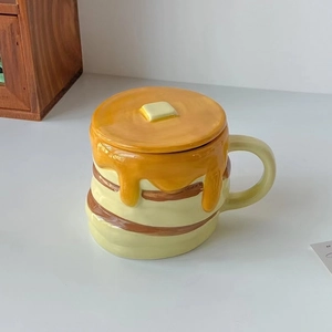 Detailed view of pumpkin-shaped ceramic mug with waffle lid and yellow syrup glaze