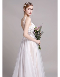 Détail du corsage en dentelle et du dos en V profond sur une robe de mariée en tulle