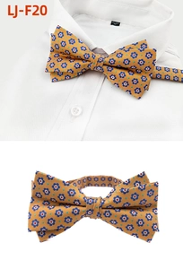 Detail of yellow floral bowtie with blue flowers on white shirt and plain background