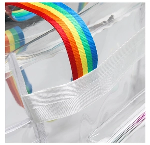 Detail of the rainbow woven strap and white webbing on the clear PVC beach tote bag