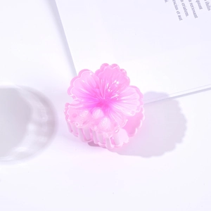 Detailed view of a pink floral hair claw clip with subtle glitter on clear plastic