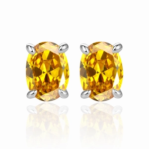 Macro detail of yellow oval-cut zircon earrings with polished silver four-claw setting