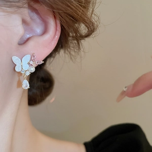 Elegant butterfly drop earrings with pearls and pink cubic zirconia on a female model