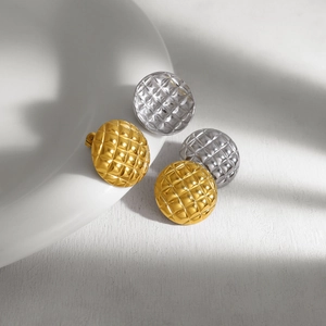 Detail of gold and silver stainless steel stud earrings with rhombus quilted texture