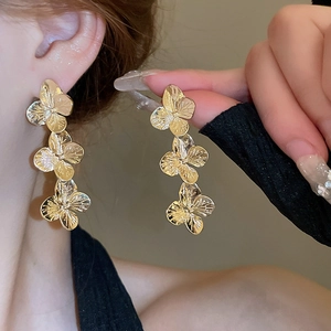 Vintage golden triple petal flower drop earrings worn by model for elegant style