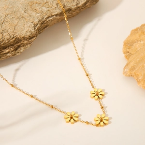 Gold daisy sunflower pendant necklace in stainless steel on aesthetic stone background