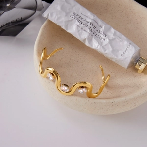 Classic 18K gold plated stainless steel wavy open bangle featuring three white zircons