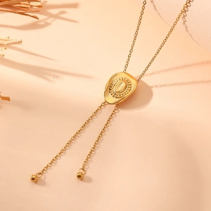 Detail of gold fringe necklace with engraved oval pendant and metallic beads