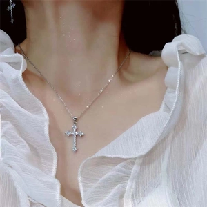 Exquisite silver cross necklace with sparkling rhinestones worn by a model