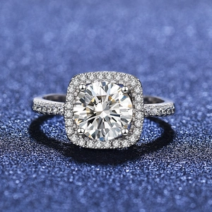 Macro detail of round brilliant halo ring with micro-paved band in silver finish