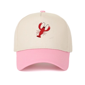 Close-up of red lobster embroidery on a beige and pink cotton baseball cap