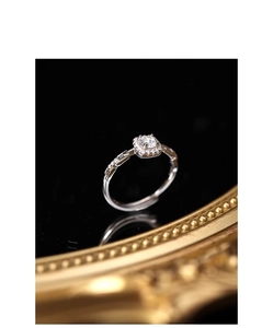 Macro shot of adjustable silver square diamond ring with side stones on black surface
