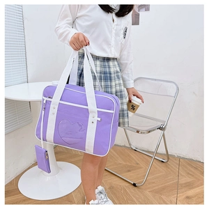 Detail of purple JK uniform handbag with heart-shaped window and small coin purse