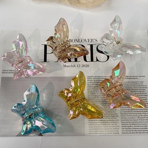 Iridescent butterfly hair claws in six colors set against a stylish fashion magazine