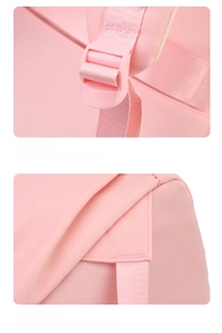 Detailed view of adjustable plastic buckles and reinforced stitching on pink nylon backpack