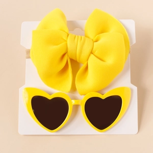 Detail of yellow bow nylon headband and matching heart-shaped sunglasses for kids