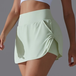 Detail of high waisted mint green skort with side pocket and built-in athletic shorts