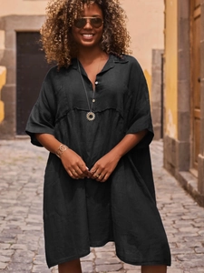 Close-up of black cotton linen shirt dress with V-neckline and metallic buttons