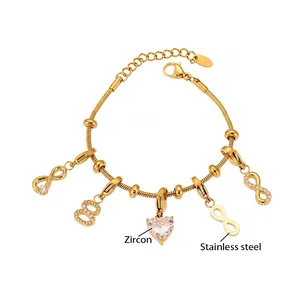 Détail du bracelet en acier doré avec breloques infini et pierres de zircon en cœur