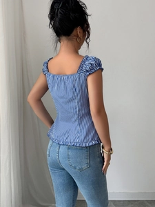 Back view of blue and white striped blouse with square neck and ruffled details