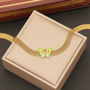 Détail du bracelet en maille dorée avec breloque papillon en émail coloré dans un coffret cadeau