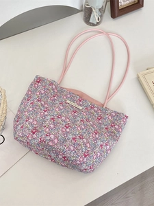 Sac fourre-tout en toile à fleurs avec anses roses et motifs floraux sur bureau blanc
