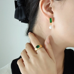 Vintage gold jewelry set featuring emerald zircon earrings with freshwater pearls on a model