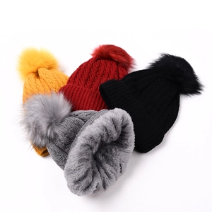 Chunky knit pom-pom beanie for women featuring warm fleece lining in multiple colors