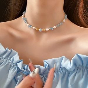 Détail du collier de perles et éclats d'aigue-marine porté sur le cou du mannequin