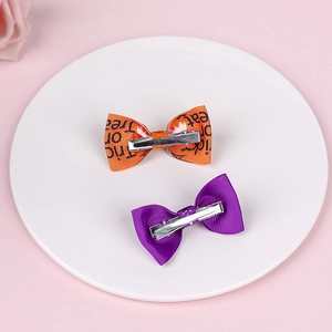 Detail of Halloween bow hair clips with Trick or Treat print and metal alligator clips