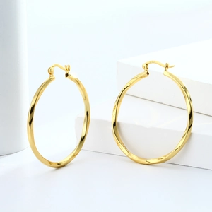 Close-up of S925 hallmark on a large gold twisted hoop earring with hollow texture