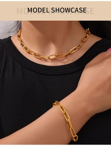 Close-up of golden interlocking twist chain necklace and bracelet set on model