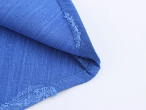 Détail du tissu denim bleu montrant la texture, les coutures et la finition soignée