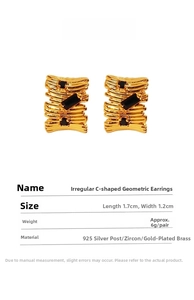 Detailed view of C-shape geometric earrings with black zircon and gold pleated brass